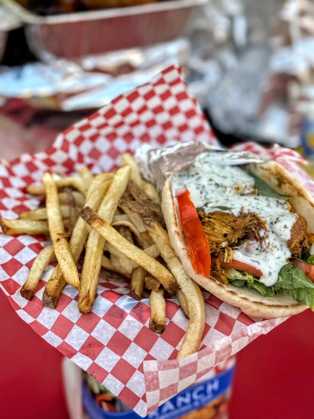 Chicken gyro with lettuce, tomato, sauce and fries