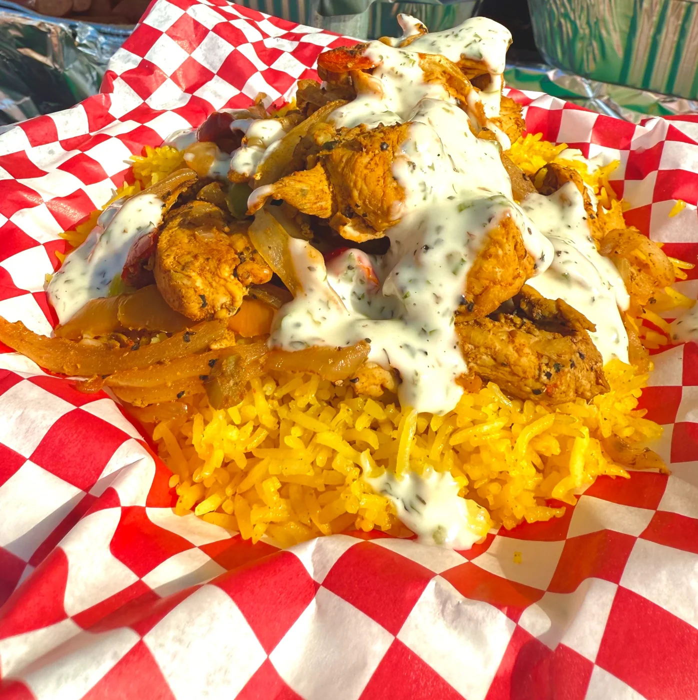 Seasoned chicken over yellow rice with creamy sauce